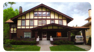 Image of the WICS Home with a light on in the front room and a small van in the driveway. A walkway leads from the sidewalk to the front door.